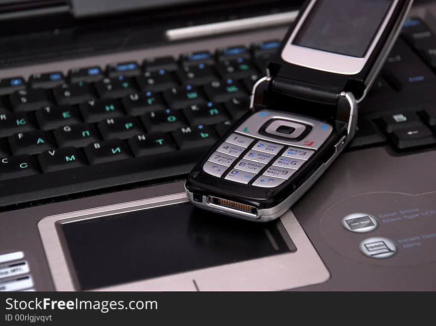 Keyboard of laptop and smartphone on it.