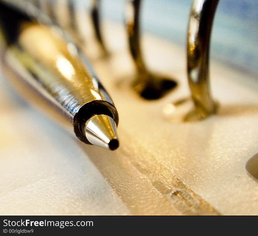 This image shows a pen laying next to a few rings. This image shows a pen laying next to a few rings.