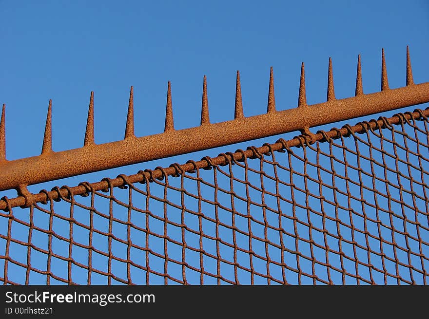 Rusty old fence with a blue sky background