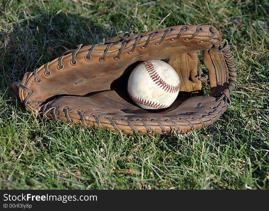 Baseball glove and ball laying in the grass. Baseball glove and ball laying in the grass.