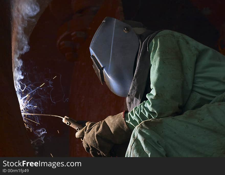 A welder working at shipyard at night. A welder working at shipyard at night