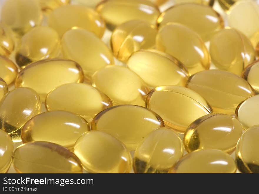 Many scattered oval, yellow pills forming an abstract background. Many scattered oval, yellow pills forming an abstract background