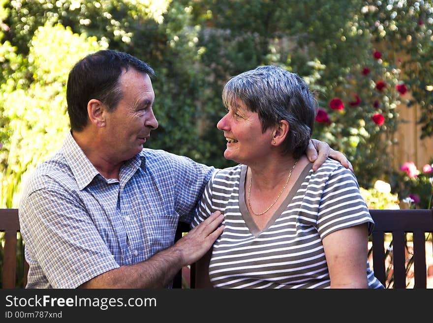 Older couple sitting on a bench having fun and laughing. Older couple sitting on a bench having fun and laughing