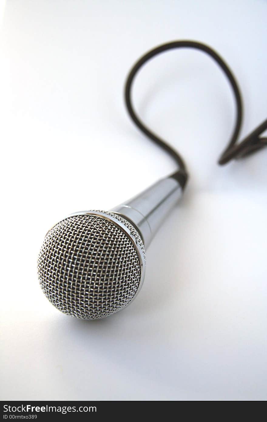 Microphone with a black cord on a white background. Microphone with a black cord on a white background.