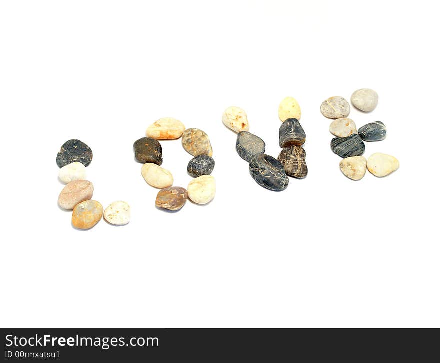 'Love' word written with stones of different shapes and colours on a white background. 'Love' word written with stones of different shapes and colours on a white background