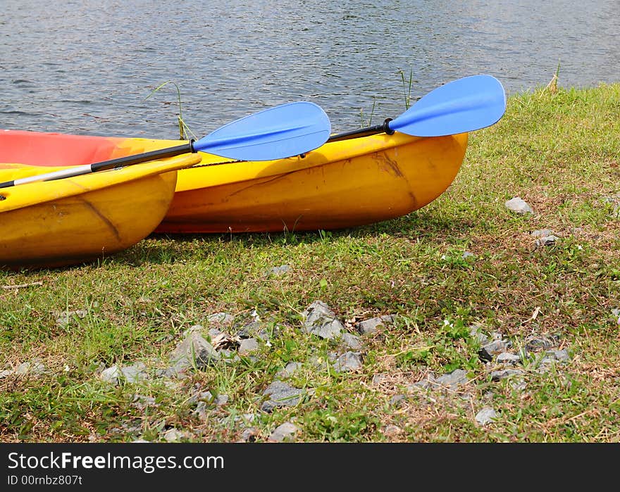 Two kayak in a similar stationary position with their oars pointing the same way. Two kayak in a similar stationary position with their oars pointing the same way