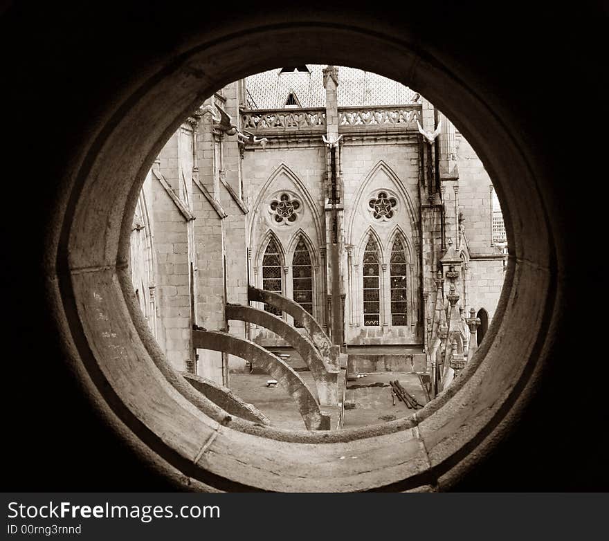 View of the Basilica del Voto National through a round stone window. In the old part of Quito, Ecuador. View of the Basilica del Voto National through a round stone window. In the old part of Quito, Ecuador