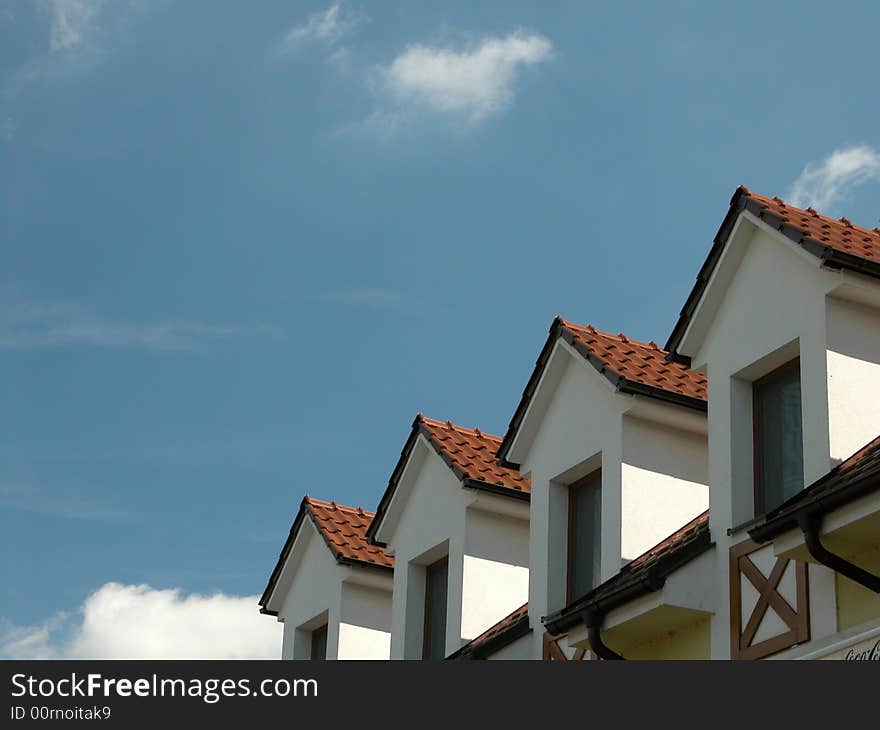 Attics of a modern hotel against a blue sky