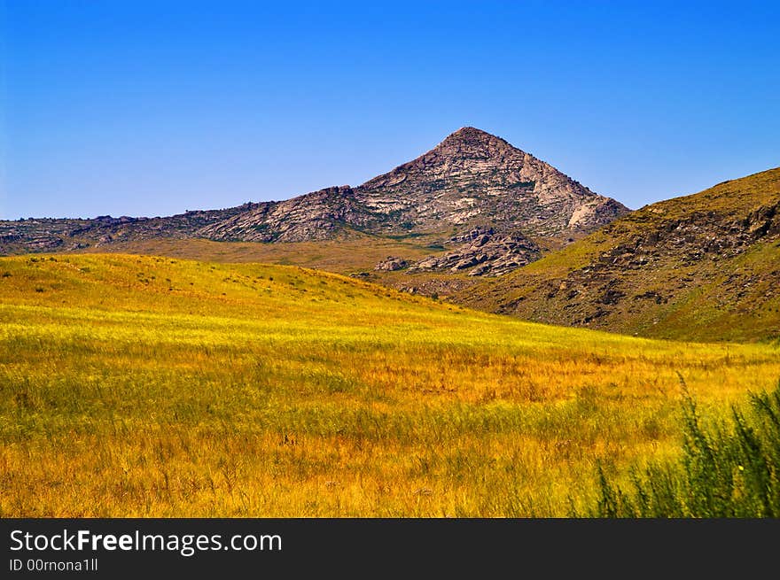 Pyramidal mountain in yellow field. Pyramidal mountain in yellow field