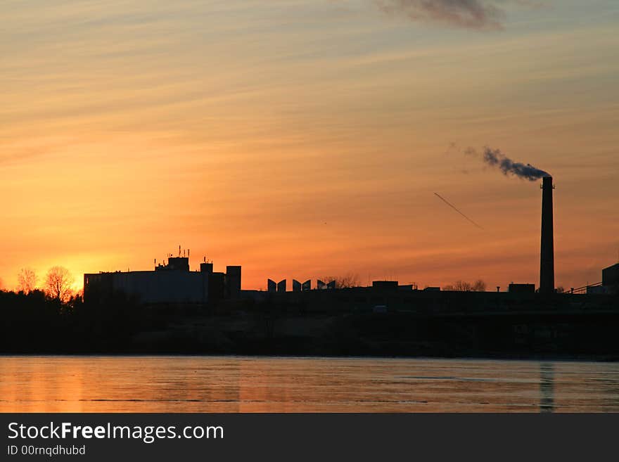 An industrial power plant pumping out smog from its smokestack into the city and nature. An industrial power plant pumping out smog from its smokestack into the city and nature