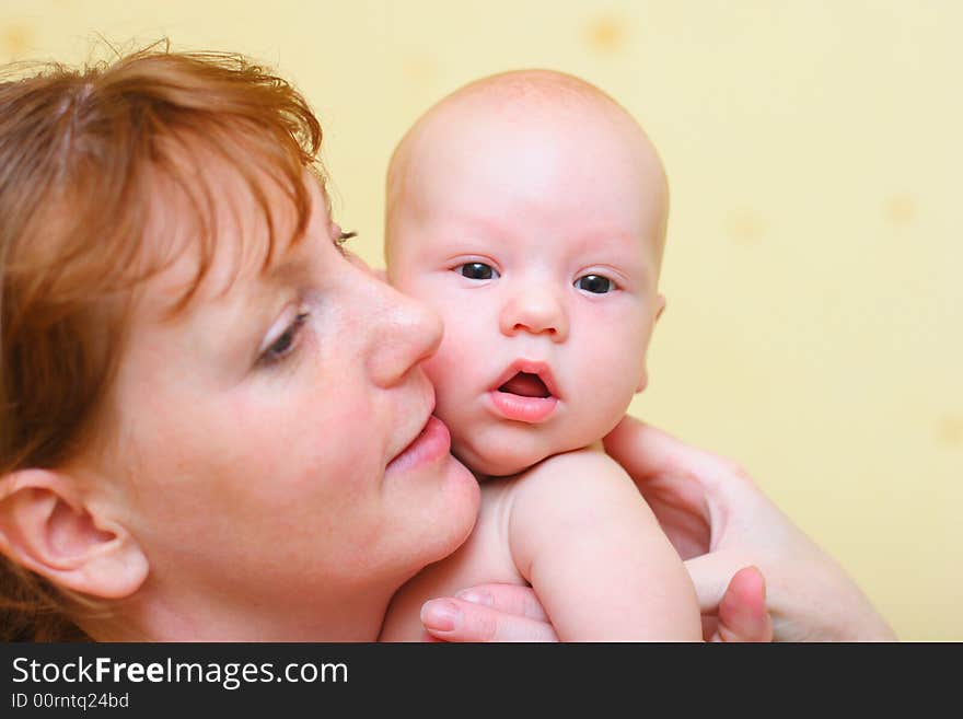 Mother gently holding baby in hands. Close-up view.