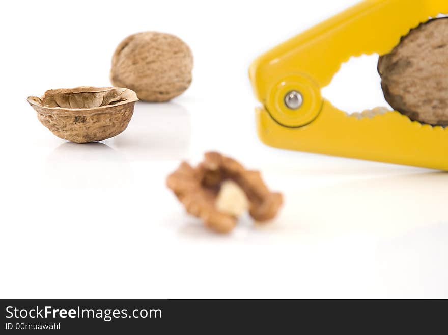 Walnut cracker and walnuts on white