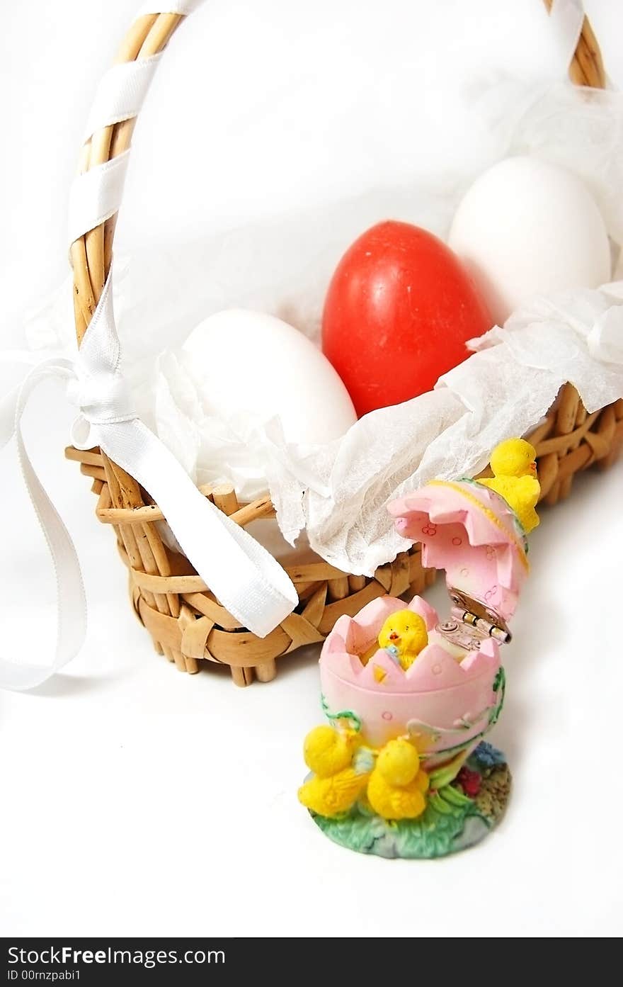 Basket with red and white eggs and bunny figurine. Basket with red and white eggs and bunny figurine