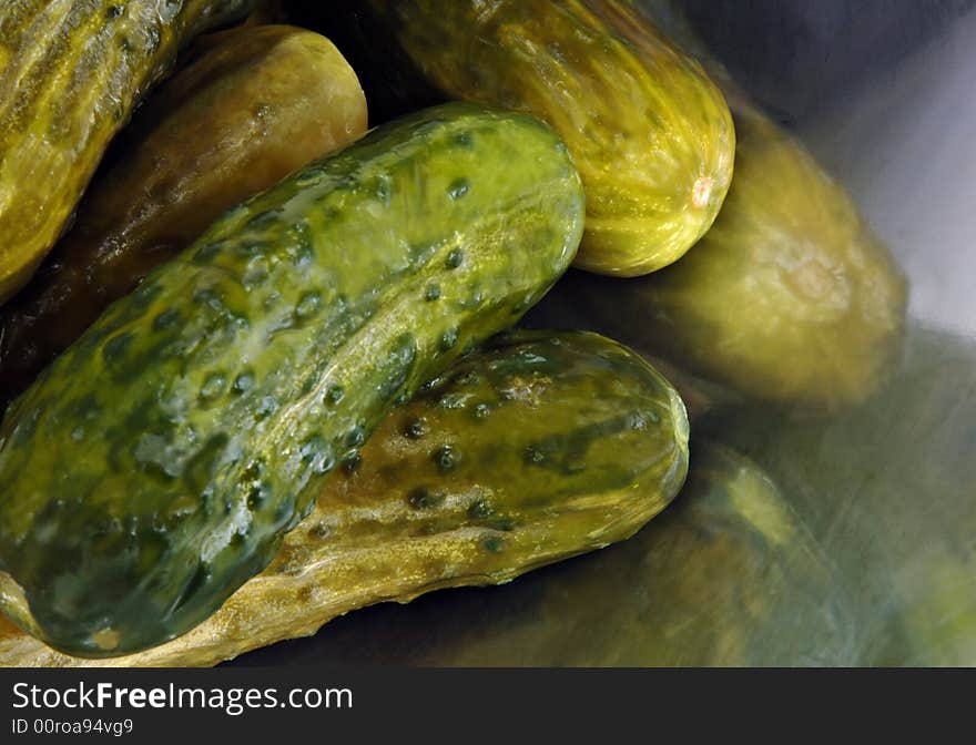 Pickled cucumbers arranged on a metal dish. Pickled cucumbers arranged on a metal dish.