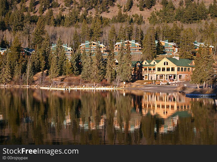 A modern mountain resort reflecting off of a calm lake. A modern mountain resort reflecting off of a calm lake