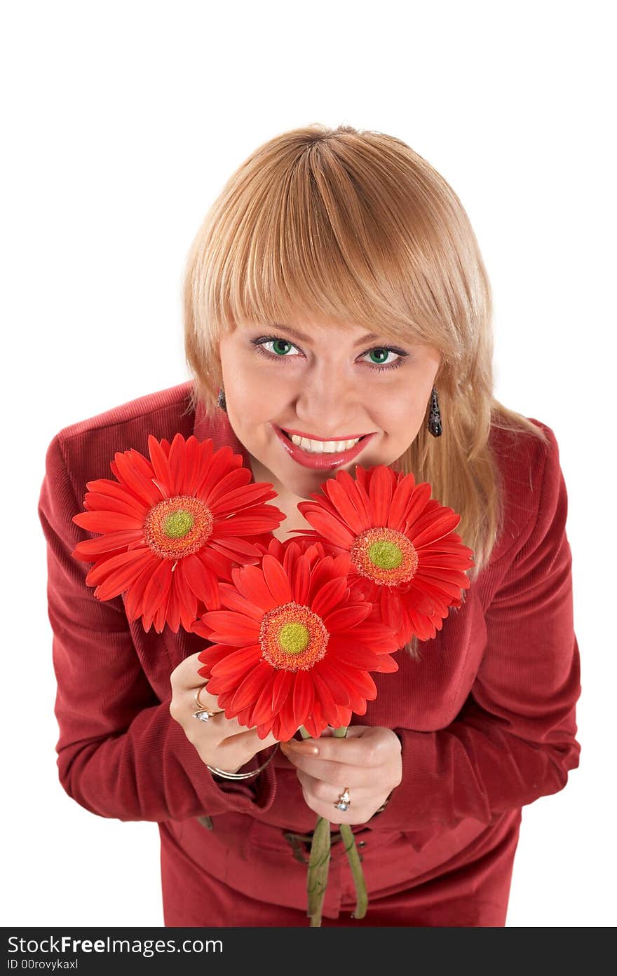 A smiling green-eyed woman with red flowers