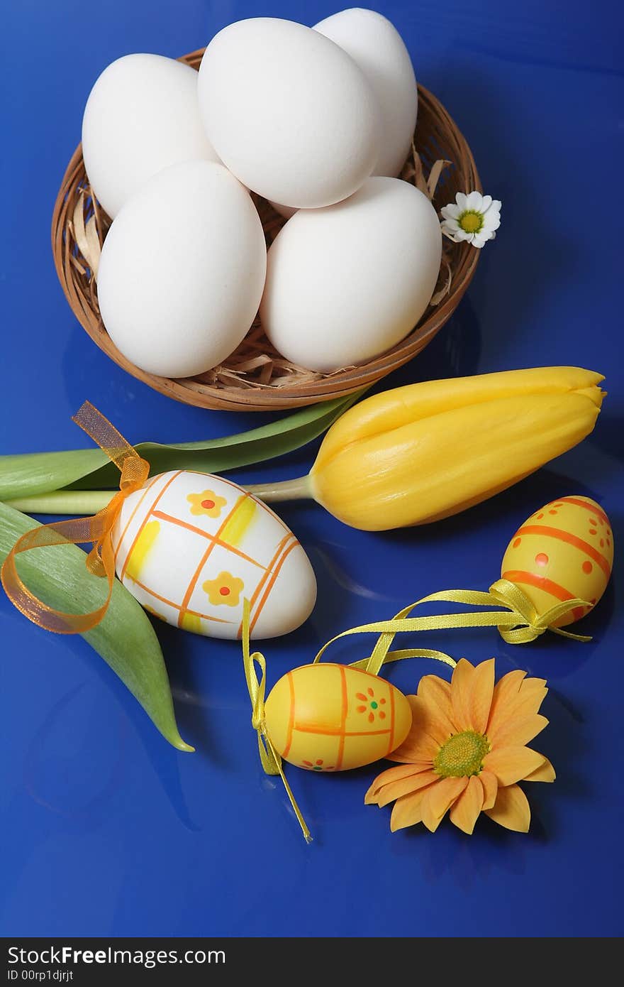 Easter eggs with yellow tulip on blue background.