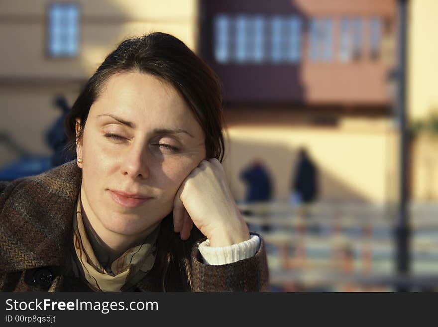 A woman is taking a brake on a sunny terrace in the city. A woman is taking a brake on a sunny terrace in the city.