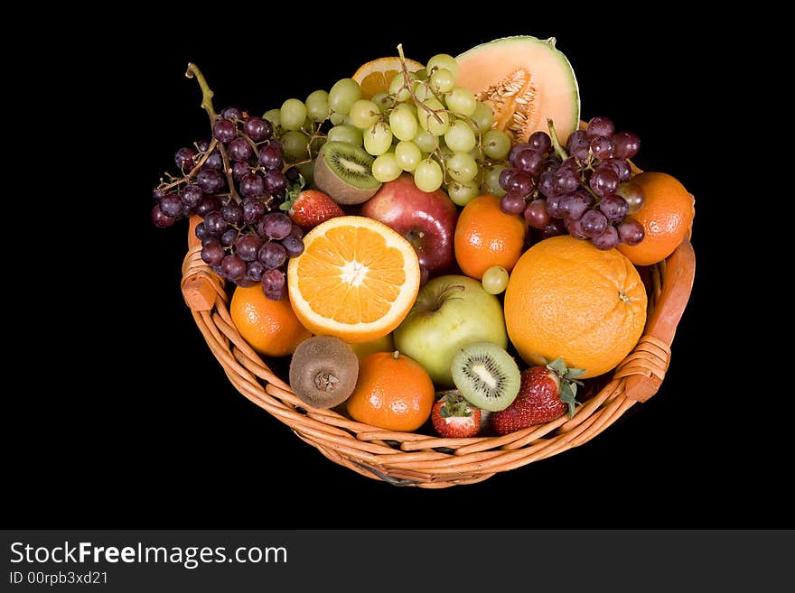 Fruit basket with many fruits before a black background