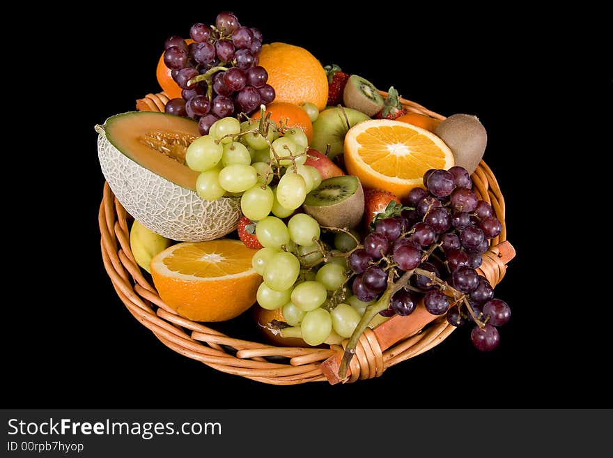 Fruit basket with many fruits before a black background