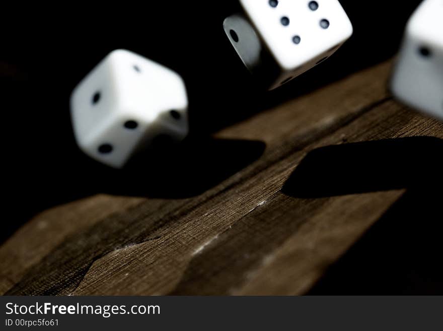 Close up photo of 3 dice rolling on a backgammon. Close up photo of 3 dice rolling on a backgammon