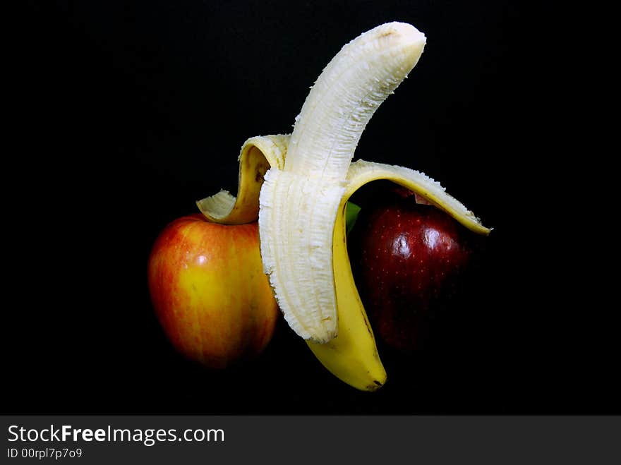 Peeled banana leaning on an apple. Peeled banana leaning on an apple.