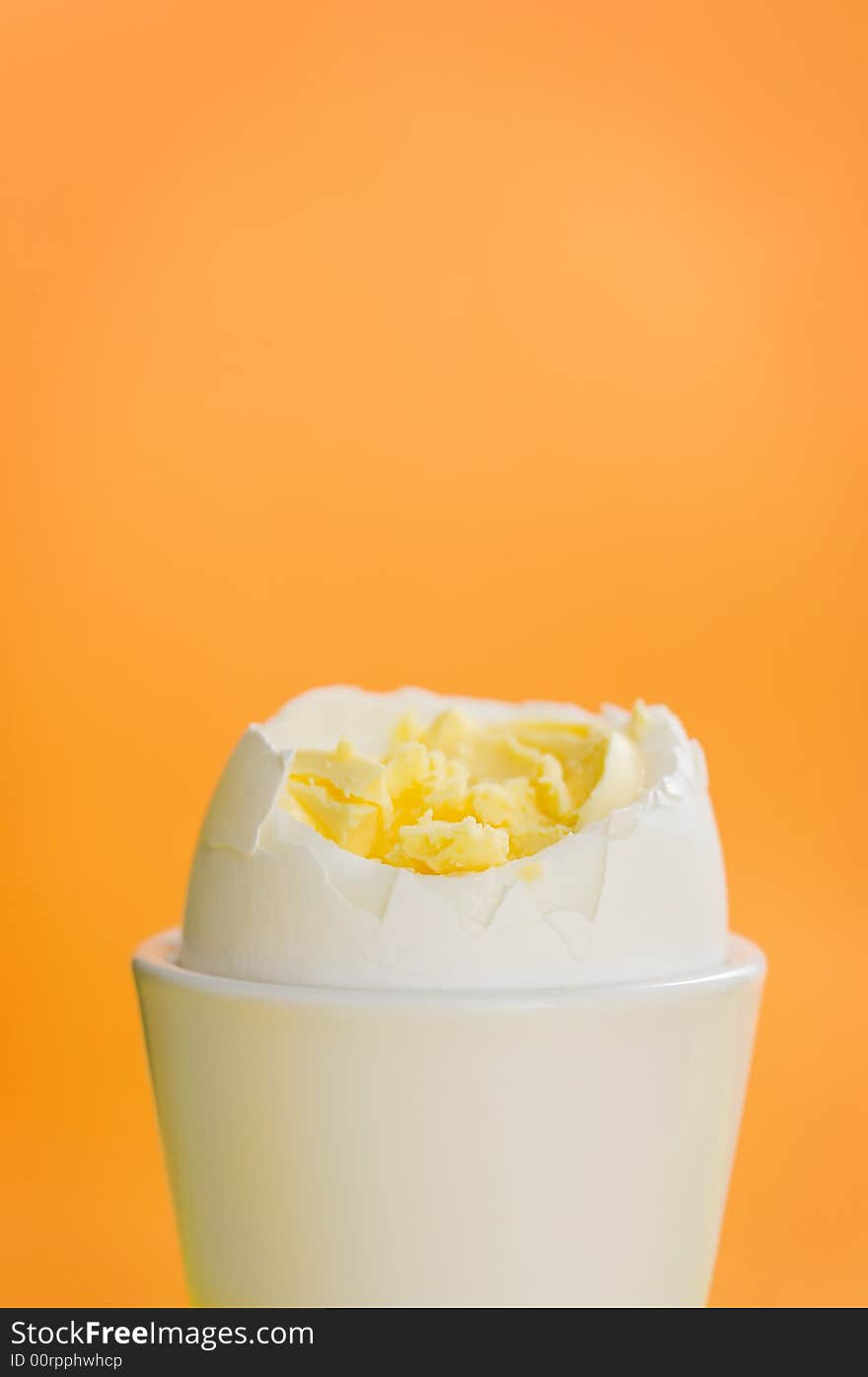 Boiled egg standing on the orange background