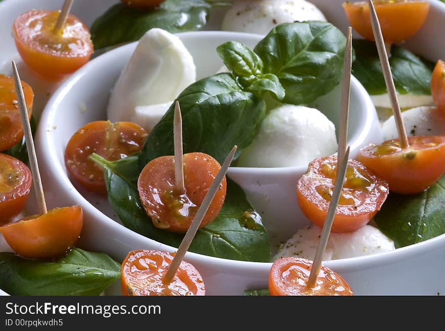 Arrangement of mozzarella and tomatoes with basil and olive oil. Arrangement of mozzarella and tomatoes with basil and olive oil.