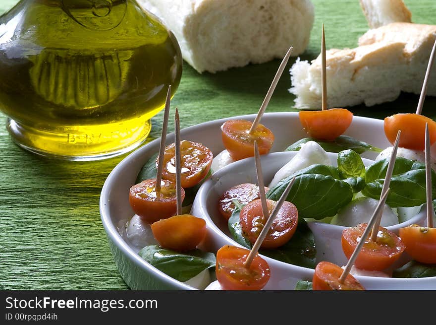 Arrangement of mozzarella and tomatoes with basil and olive oil. Arrangement of mozzarella and tomatoes with basil and olive oil.