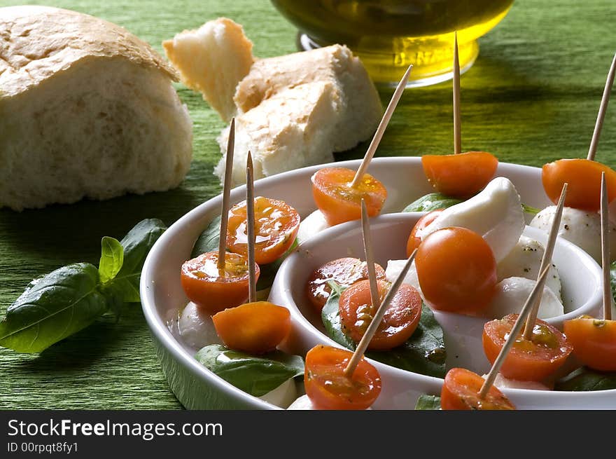 Arrangement of mozzarella and tomatoes with basil and olive oil. Arrangement of mozzarella and tomatoes with basil and olive oil.