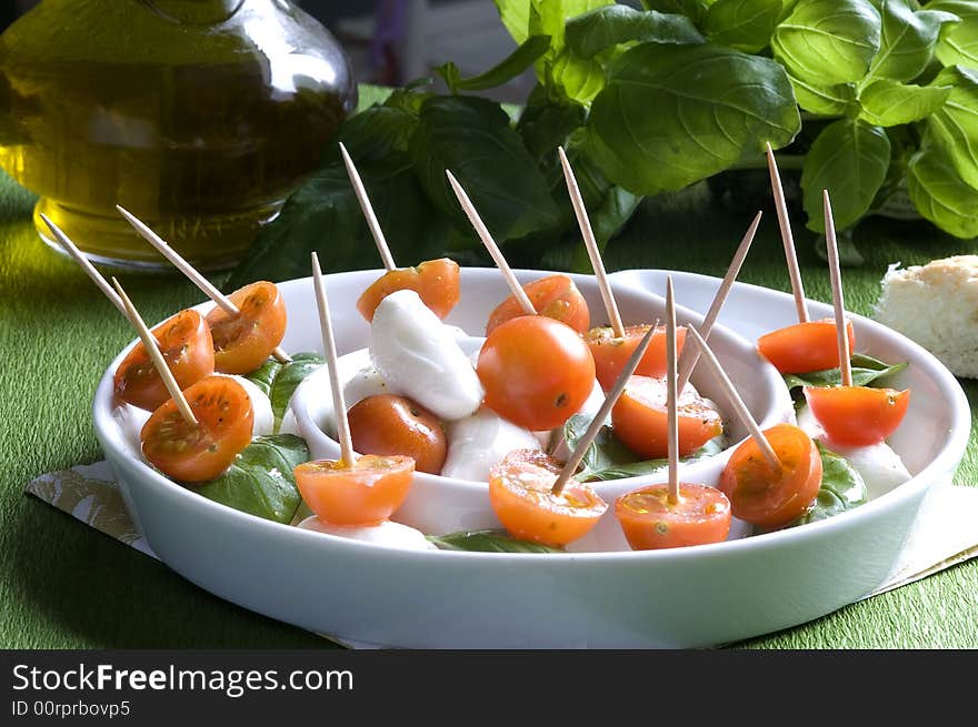 Arrangement of mozzarella and tomatoes with basil and olive oil. Arrangement of mozzarella and tomatoes with basil and olive oil.