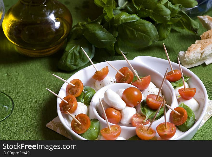 Arrangement of mozzarella and tomatoes with basil and olive oil. Arrangement of mozzarella and tomatoes with basil and olive oil.