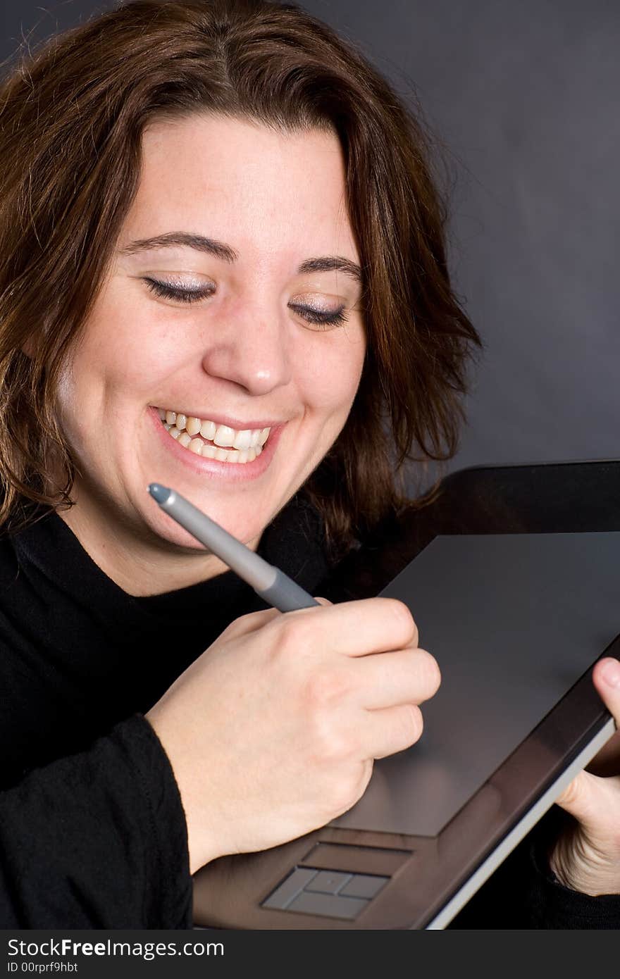 Laughing woman, while drawing near her body on the digitizer tablet. Laughing woman, while drawing near her body on the digitizer tablet.