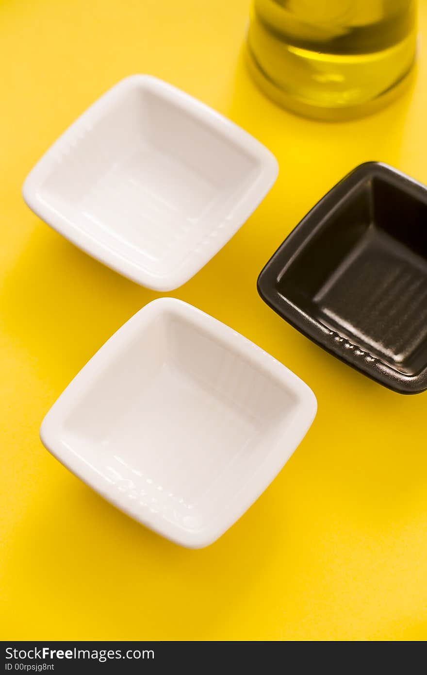 Empty vases and olive oil bottle over a yellow background