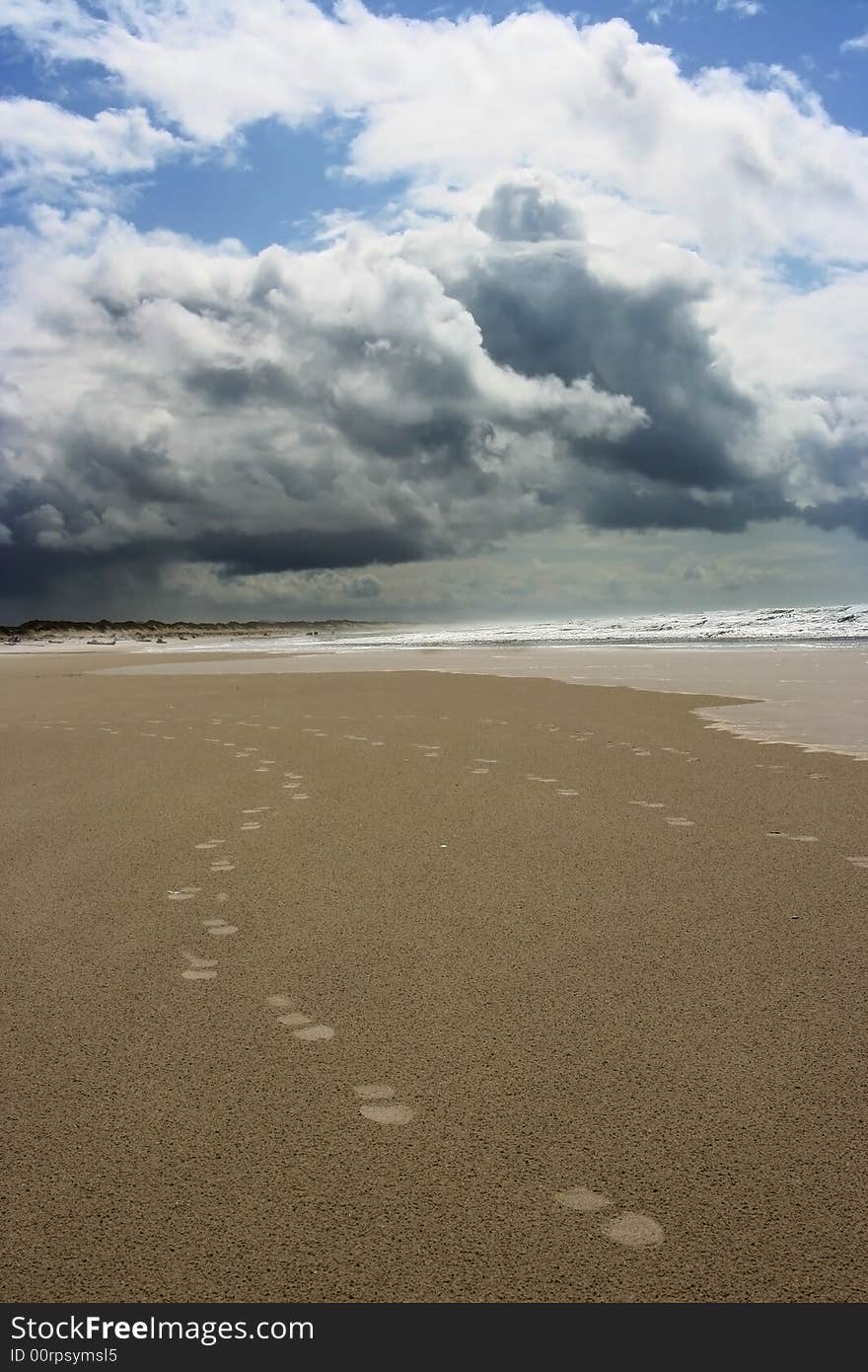 A pair beachcombers footprints track along a lonely beach. A pair beachcombers footprints track along a lonely beach