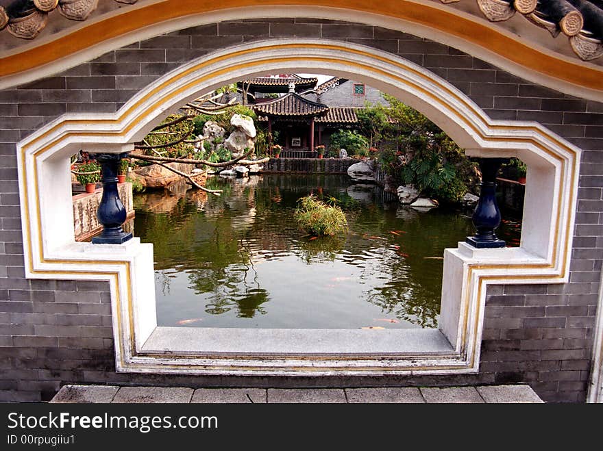 A fan-shaped window on the grey-bricked wall in a Chinese traditional ancient garden,Qinghui Garden,Shunde,Guangdong,China,Asia. A fan-shaped window on the grey-bricked wall in a Chinese traditional ancient garden,Qinghui Garden,Shunde,Guangdong,China,Asia.