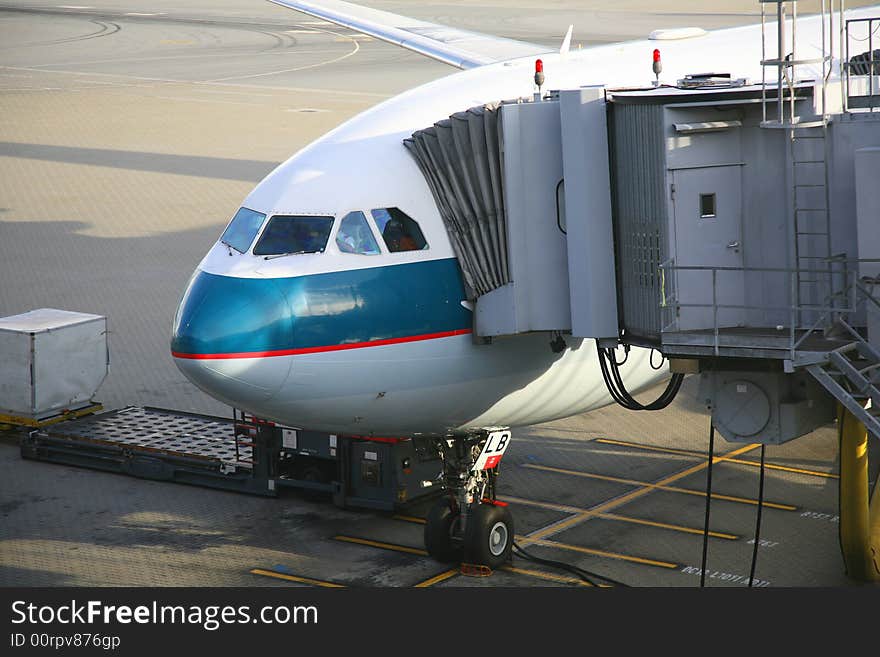 An airplane uploading passengers in the airport. An airplane uploading passengers in the airport