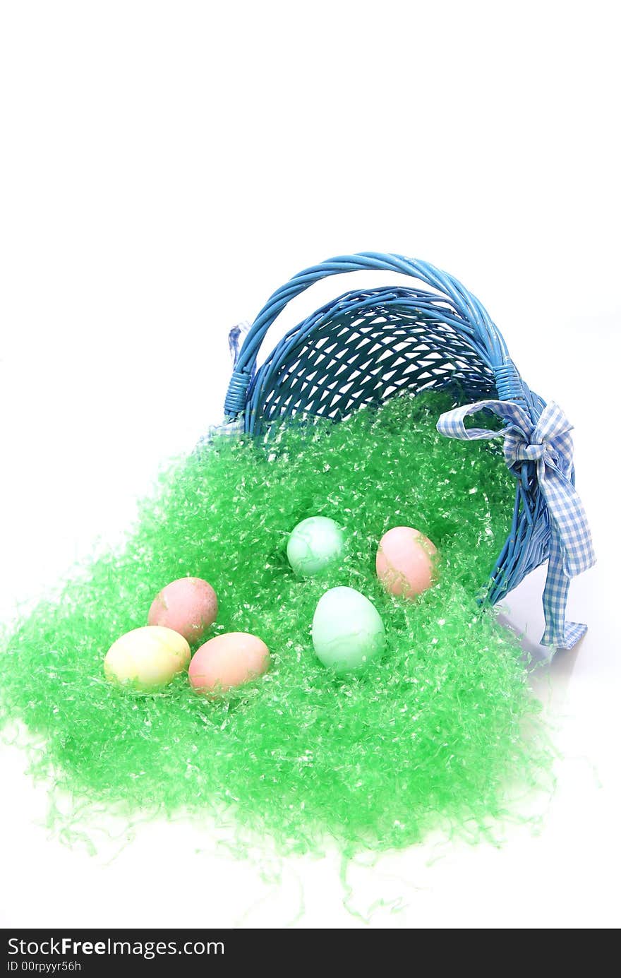 Pastel colored easter eggs and green grass spilling out of a country blue colored easter basket. Pastel colored easter eggs and green grass spilling out of a country blue colored easter basket.