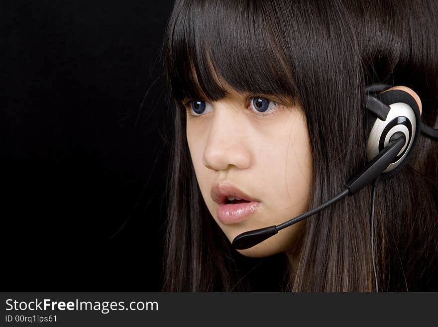 Young teenager communicates with a Headset befor a black background. Young teenager communicates with a Headset befor a black background