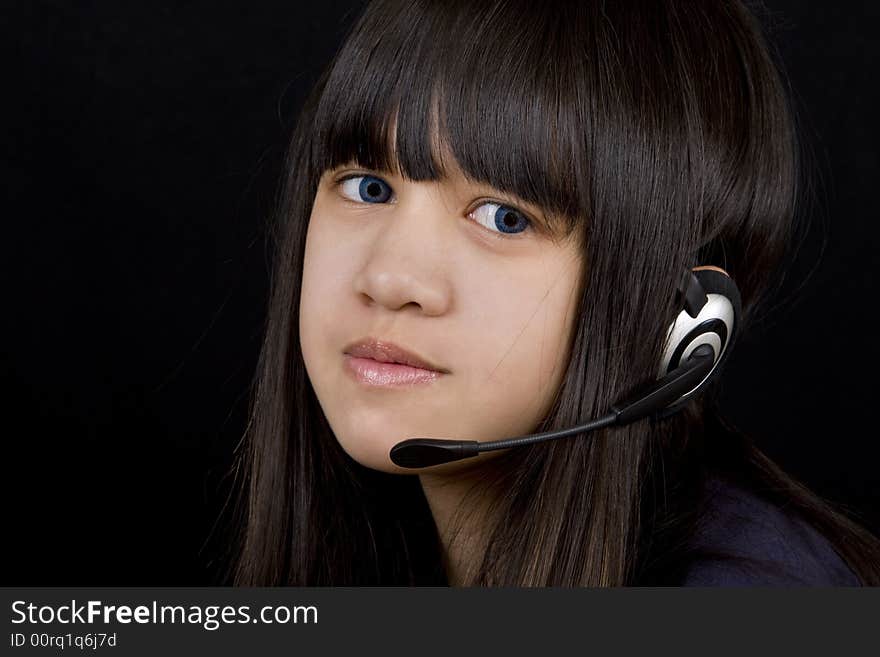 Young teenager communicates with a Headset befor a black background. Young teenager communicates with a Headset befor a black background