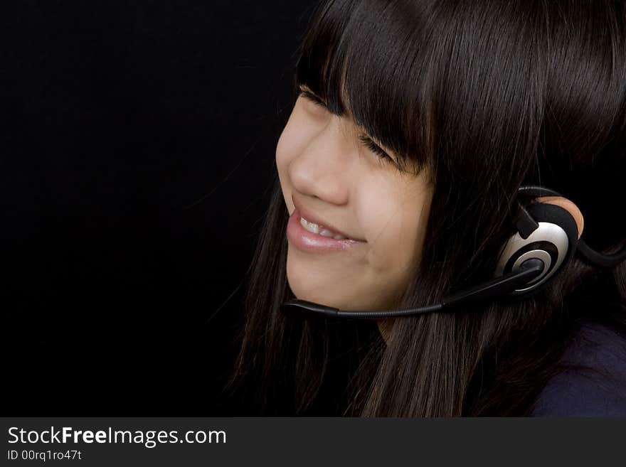 Young teenager communicates with a Headset befor a black background. Young teenager communicates with a Headset befor a black background