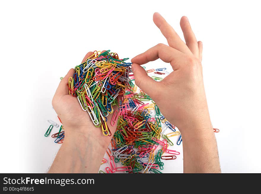 Hands holds paper clips picking one isolated on white