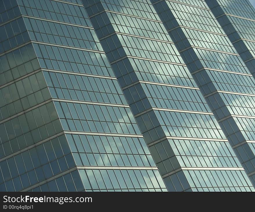 The glass of an urban highrise reflecting sky and clouds. The glass of an urban highrise reflecting sky and clouds.