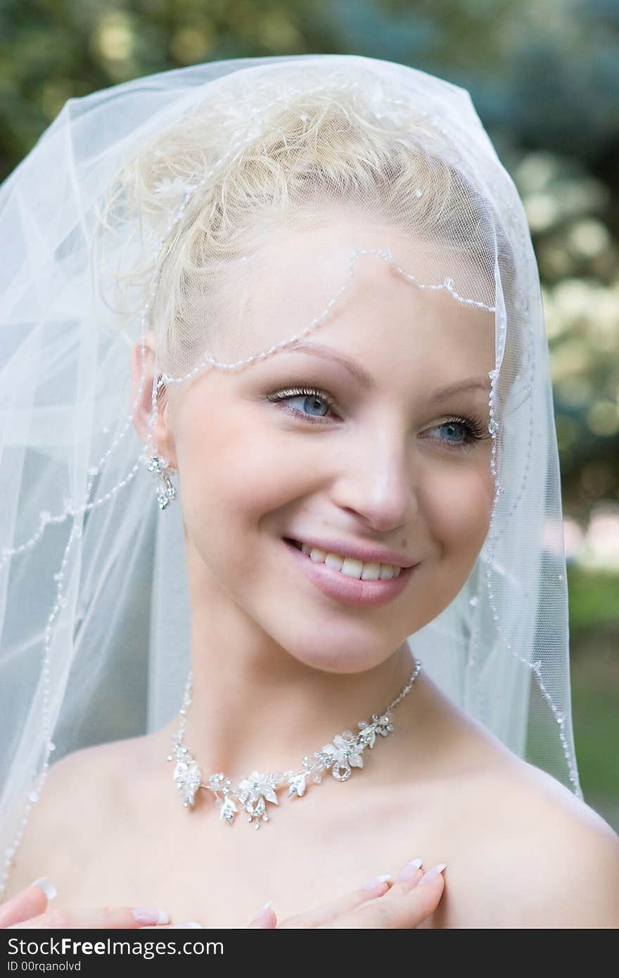 Beautiful blond blue-eyes bride laughs in the meadow. Beautiful blond blue-eyes bride laughs in the meadow