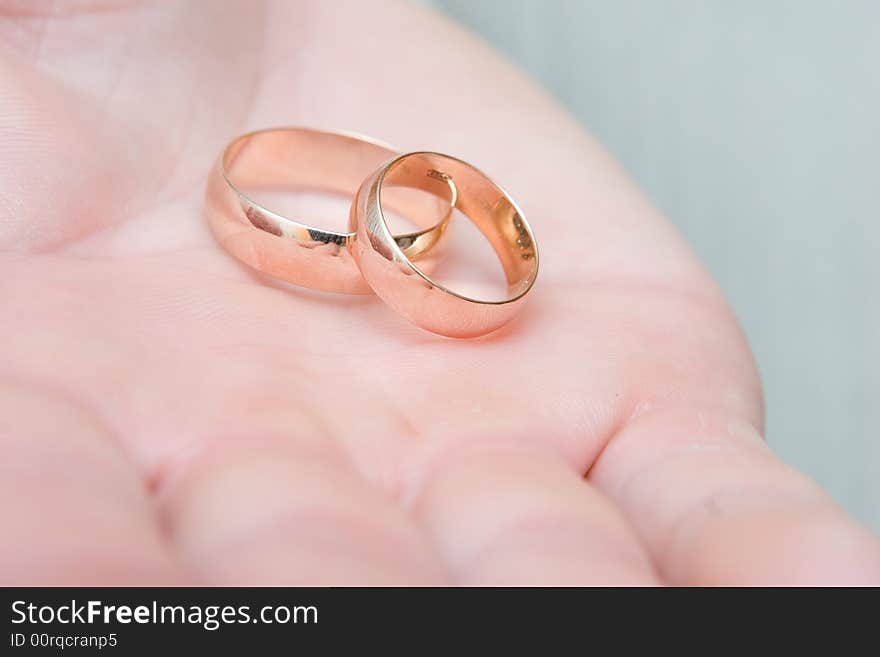 Gold wedding rings on a wide palm. Gold wedding rings on a wide palm