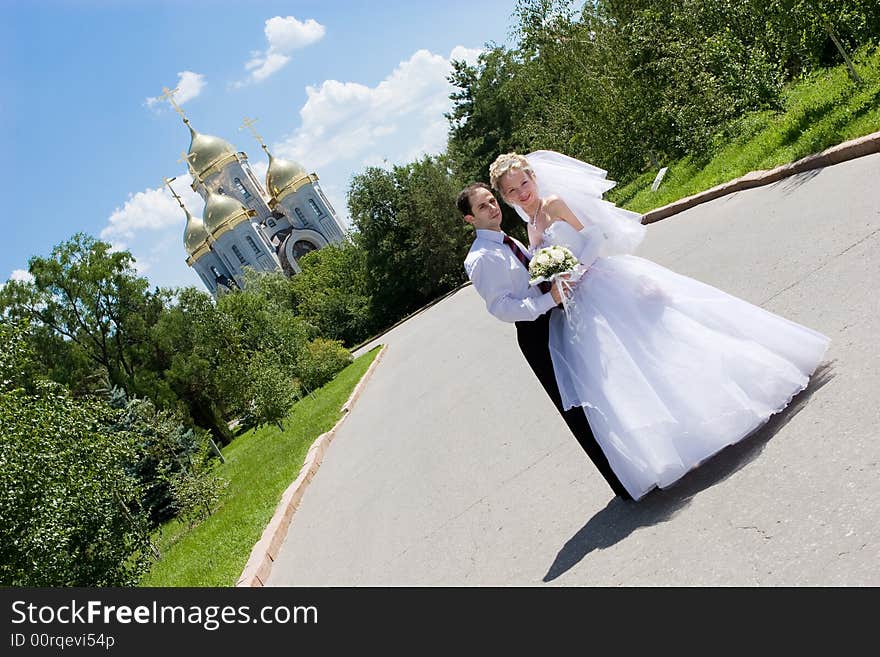 A Happy Bride And A Groom Near The Church