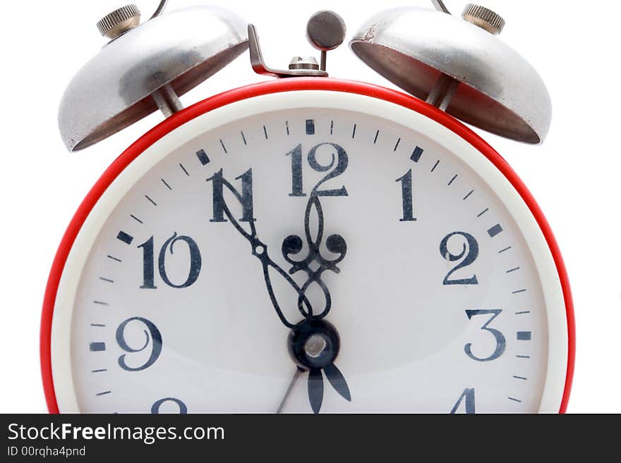 Old red alarm clock on a white background