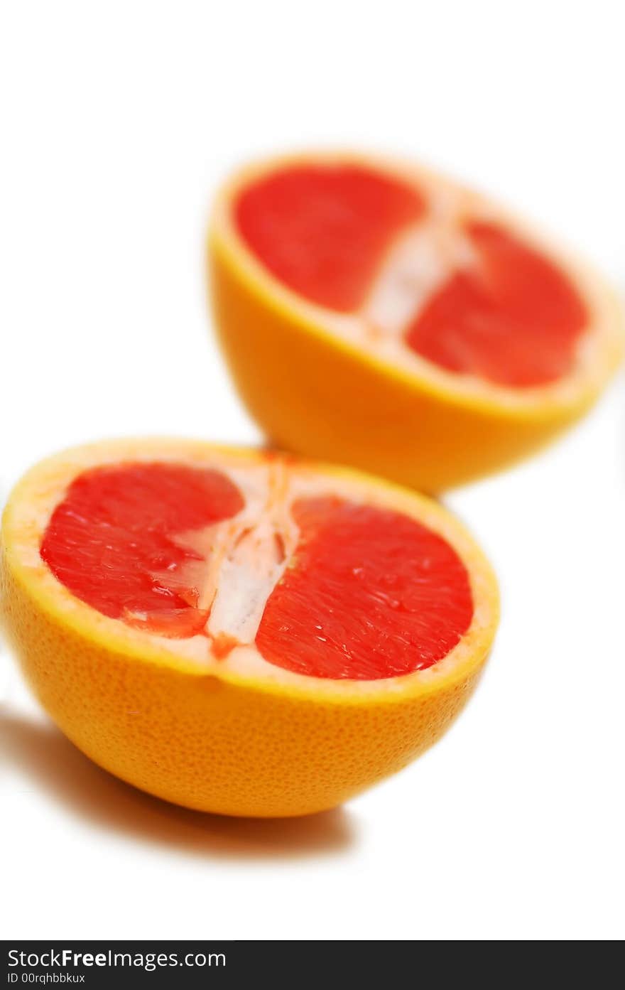 Halved red grapefruit on a white background