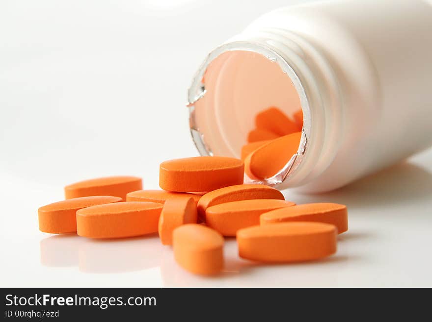 Orange medicine pills on a light background