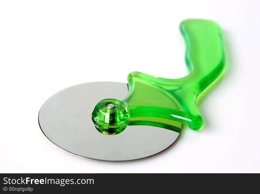 Green pizza cutter on a light background